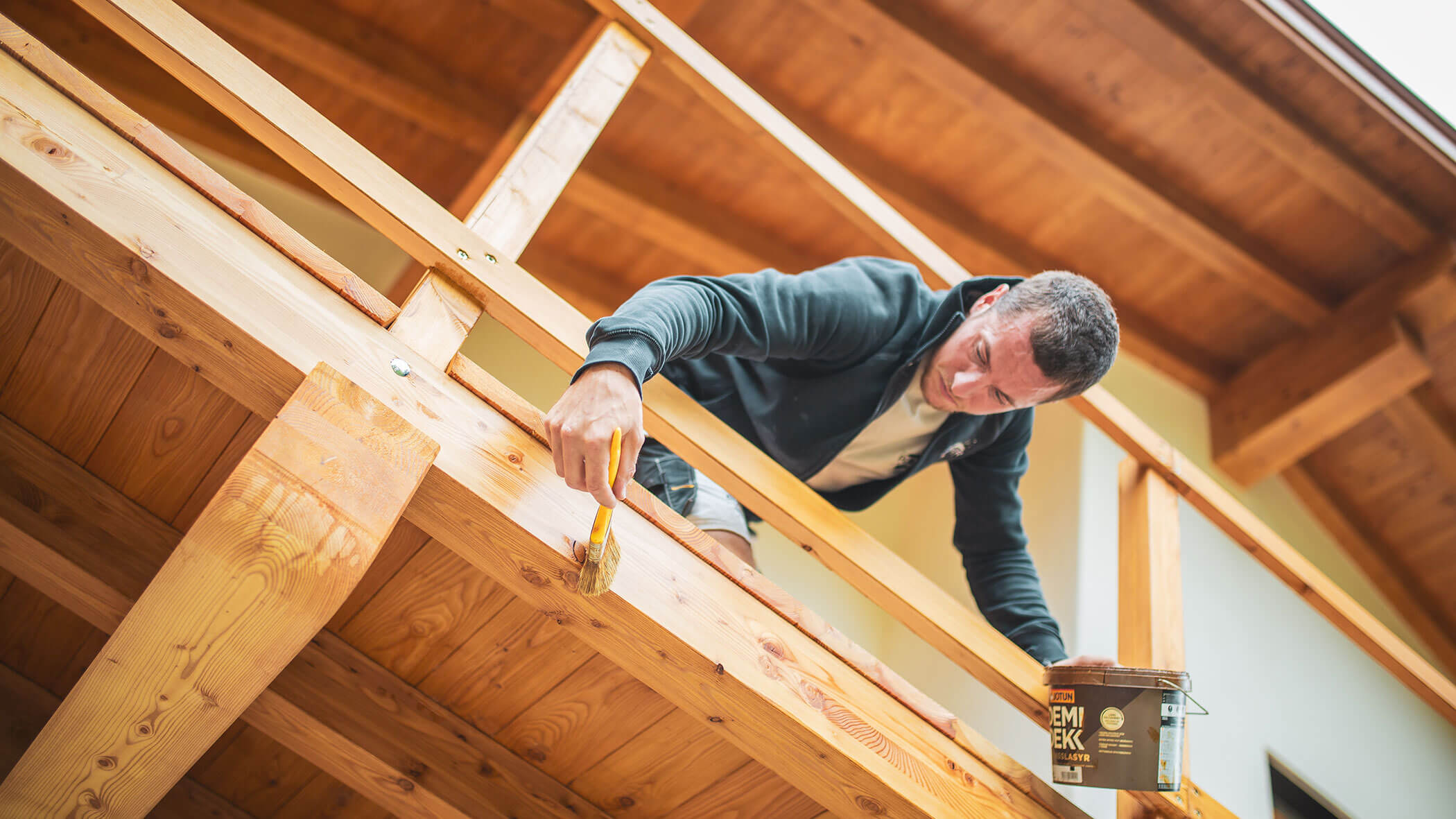 Arbeiter streicht die Außenseite des Balkons - Ploner KG