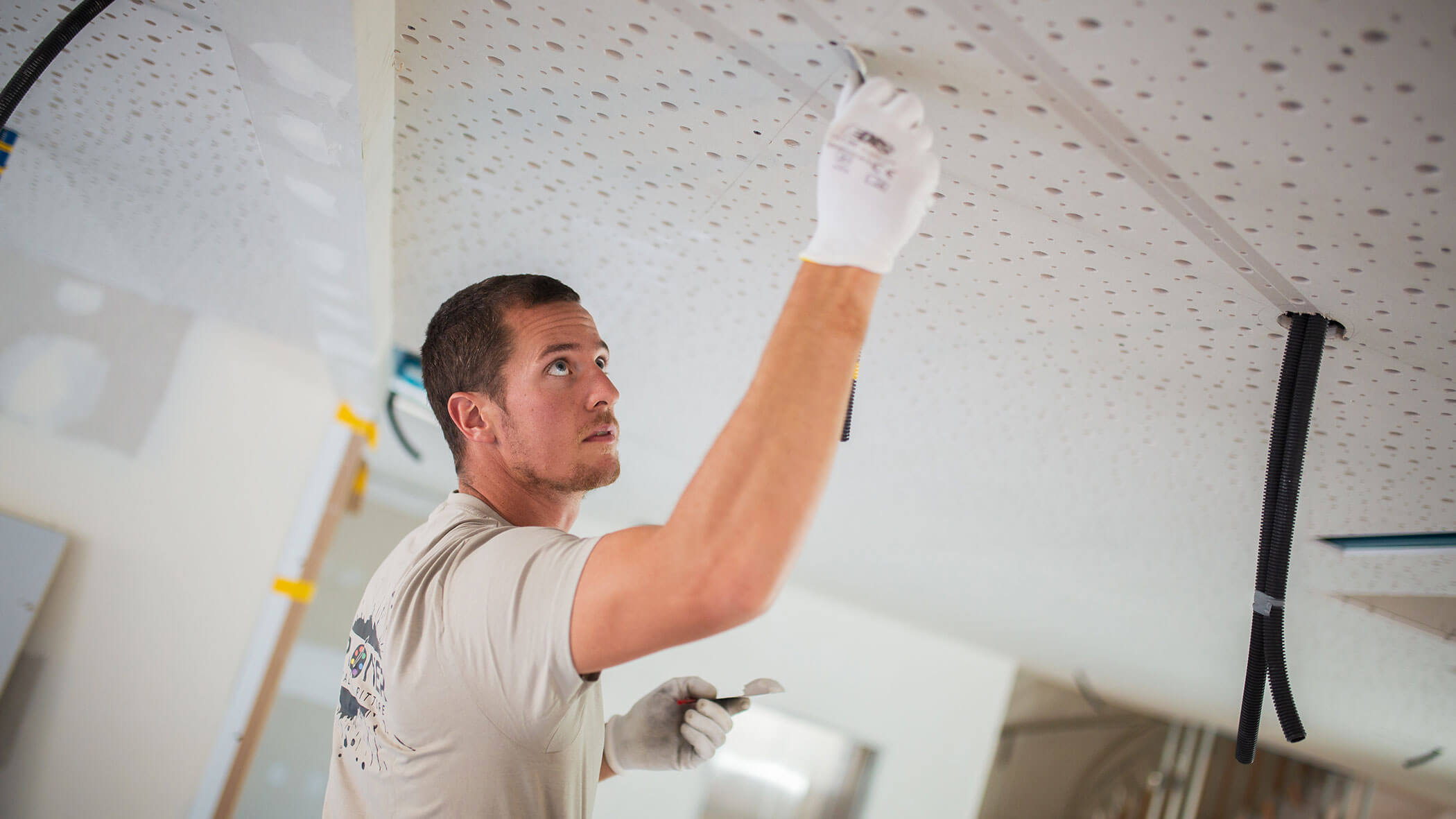 Mitarbeiter deckt Löcher in der Decke ab - Ploner KG