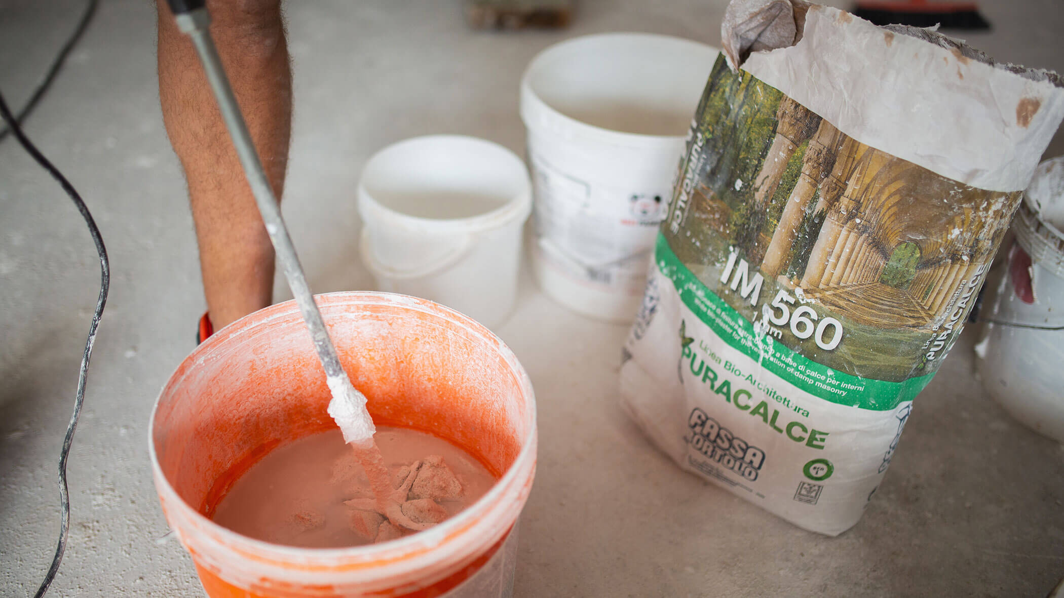 Eimer mit weißer Farbe wird mit einer Maschine umgerührt - Ploner KG